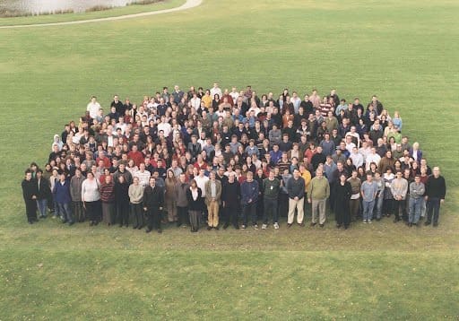 A photograph of many of the contributors of the Human Genome Project. They are outside on the Wellcome Genome Campus, the photo was taken in the year 2000.